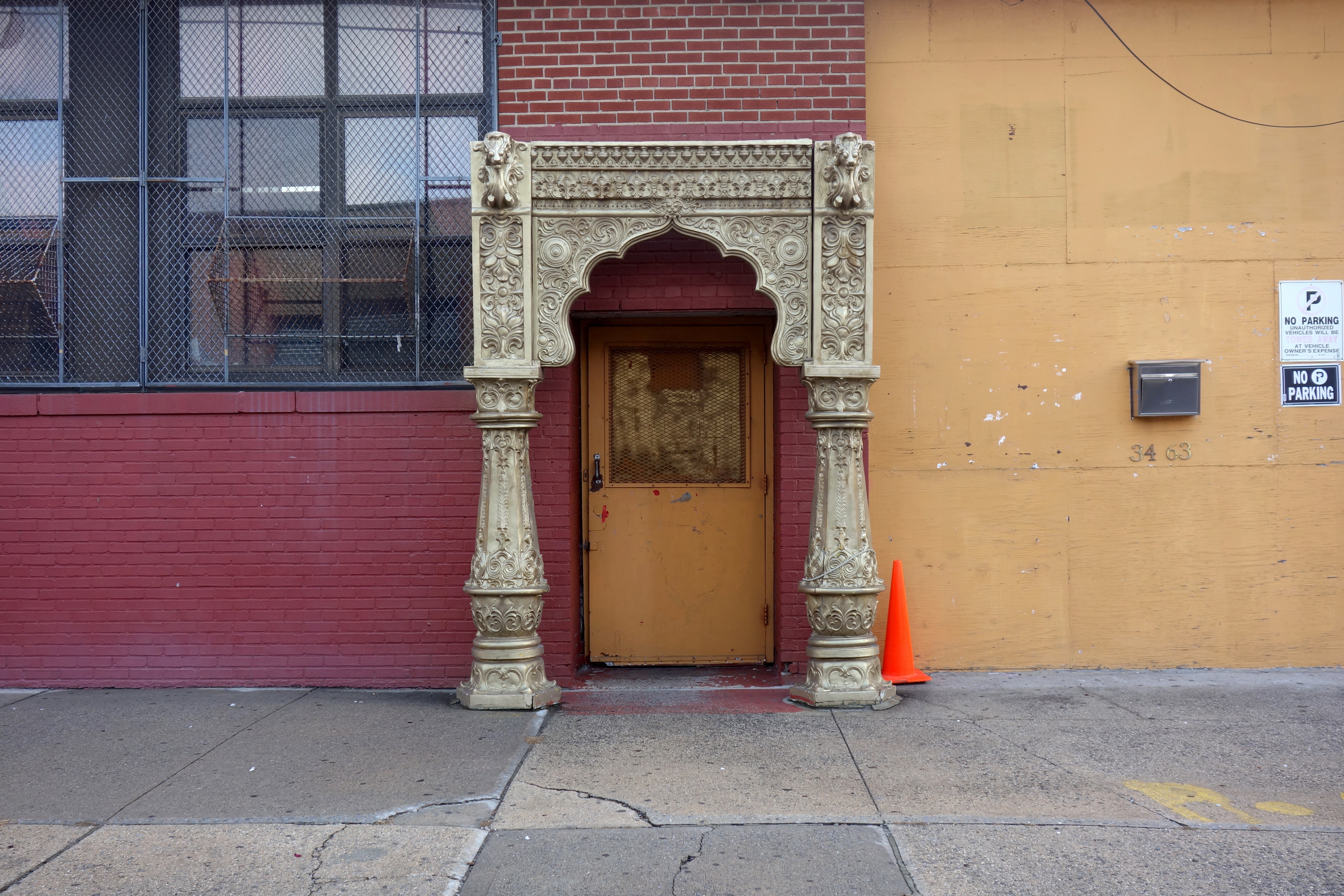 A view of an industrial building in the background with an archway placed in front of it.  